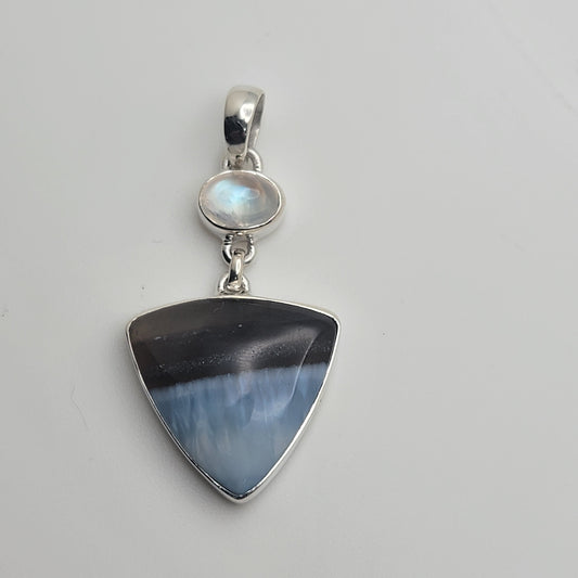 Elegant Blue Opal and Moonstone 925 Sterling Silver Pendant featuring a triangular blue opal stone complemented by a shimmering moonstone. This artisan jewelry piece embodies ocean colors, making it perfect as casual jewelry or a thoughtful Gift for Her. Ideal for those who love opal and moonstone jewelry, it serves as both a stylish accessory and a healing gemstone.